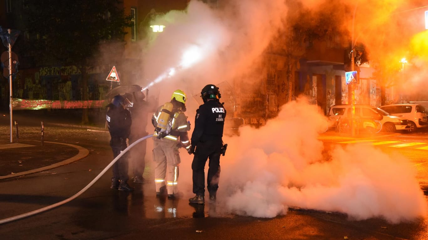 Die Feuerwehr löscht brennende Barrikaden: Die Arbeiten waren nur unter Polizeischutz möglich.