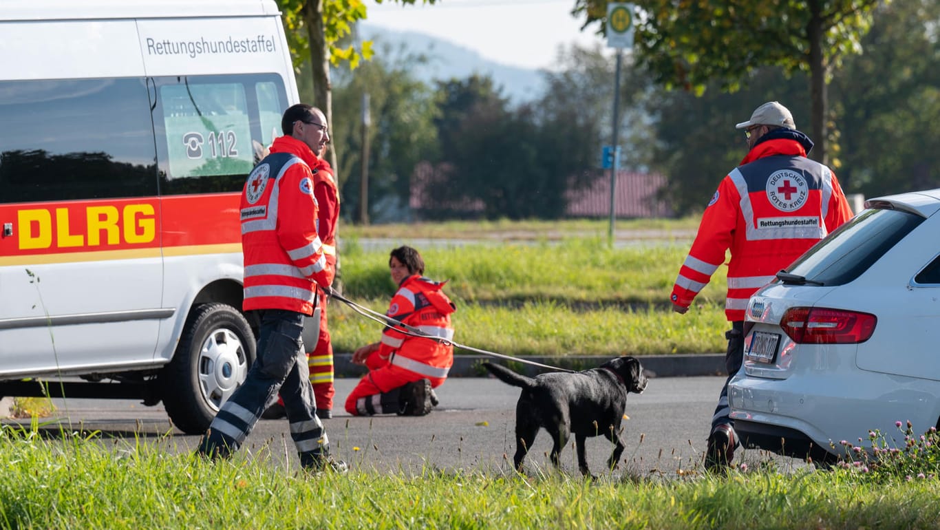 Bayern, Furth im Wald: Einsatzkräfte mit einem Suchhund stehen auf einem Parkplatz an der deutsch-tschechischen Grenze.