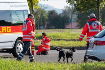 Bayern, Furth im Wald: Einsatzkräfte mit einem Suchhund stehen auf einem Parkplatz an der deutsch-tschechischen Grenze.