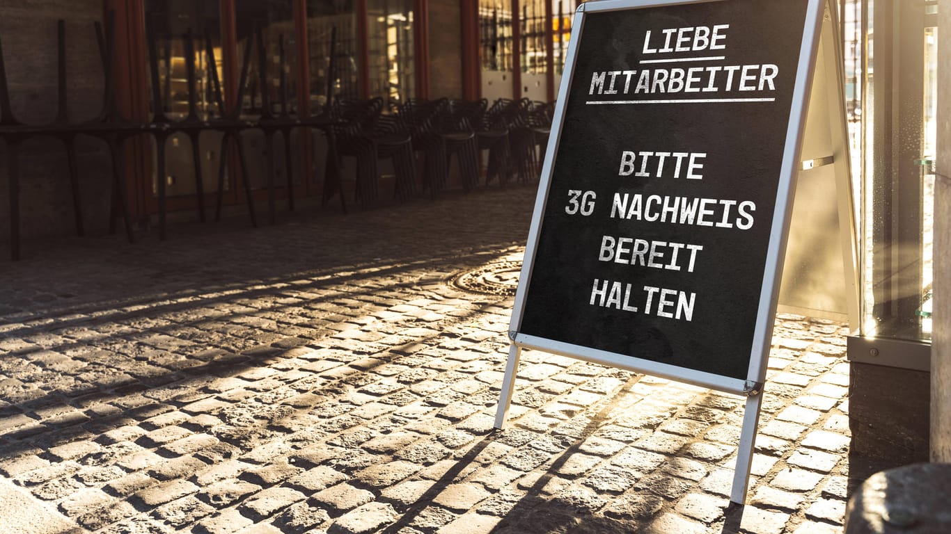 "Liebe Mitarbeiter, bitte 3G-Nachweis bereit halten" steht auf einem Schild: In Bayern müssen Menschen mit beruflichem Kundenkotakt nun auch den Nachweis erbringen.