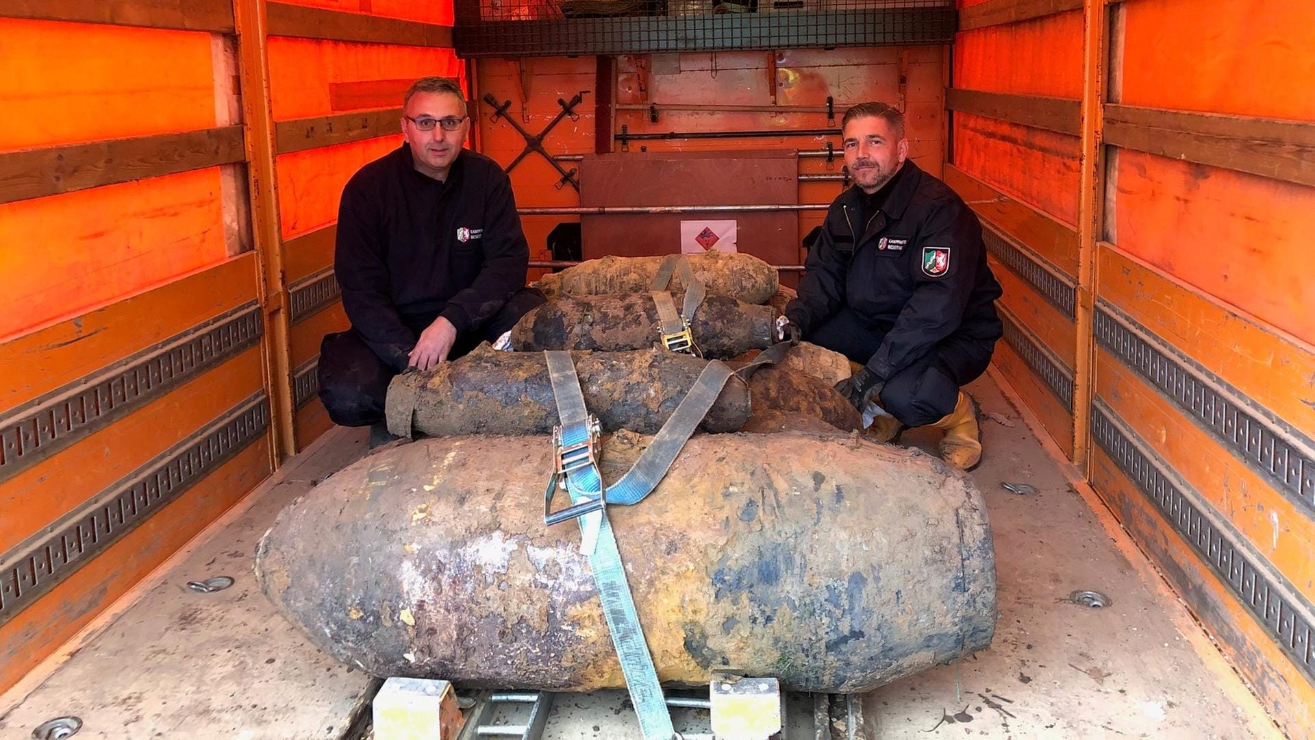 Michael Daenecke und Marcel Biewald vom Kampfmittelbeseitigungsdienst der Bezirksregierung Düsseldorf mit vier der fünf entschärften Bomben.