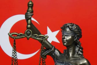 Die Justitia vor dem Hintergrund der Nationalflagge der Türkei (Symbolbild): In der Türkei hat ein Gericht einen Deutschen wegen "Terrorpropaganda" verurteilt.