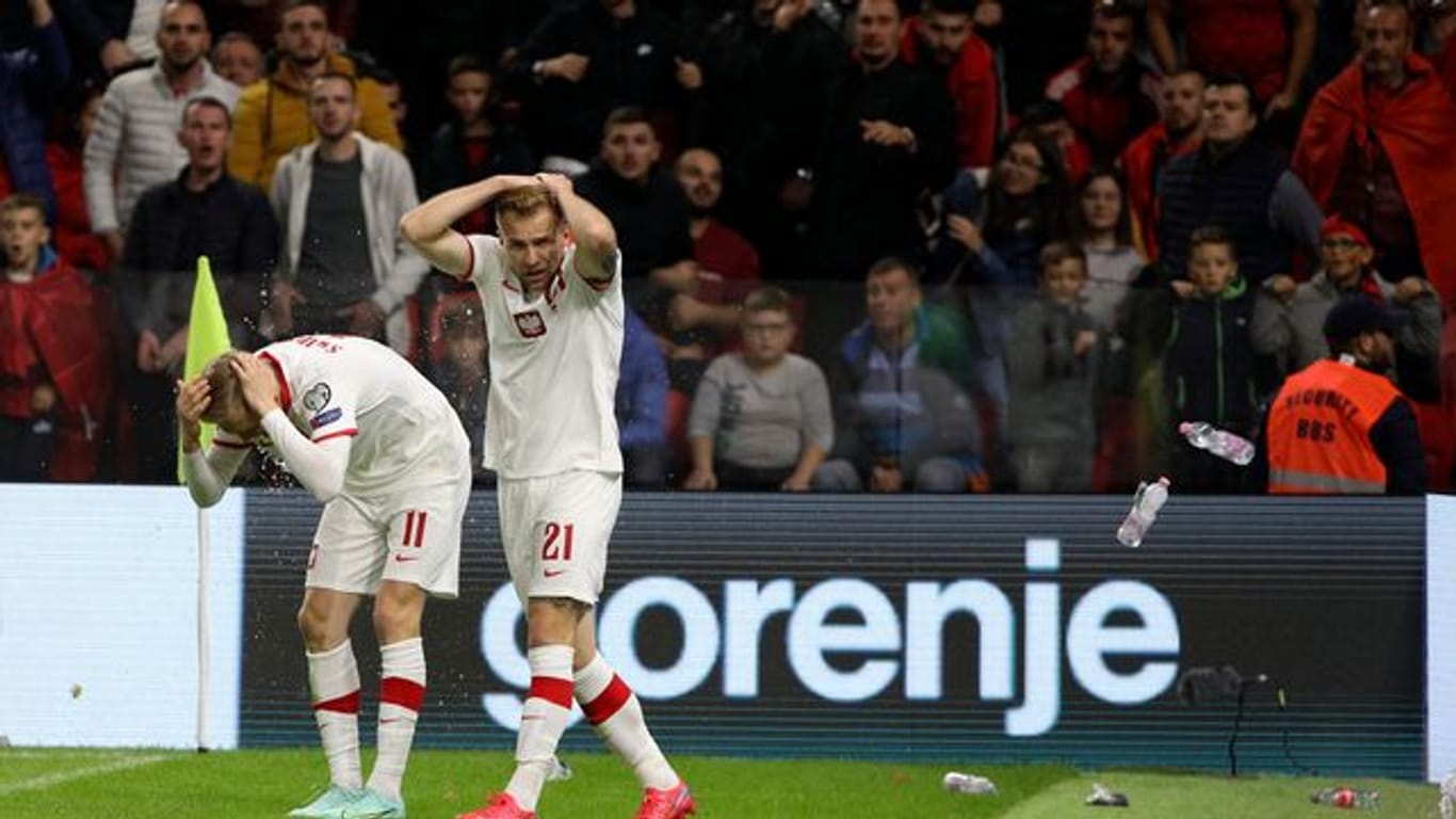 Polen Spieler schützen sich vor den Flaschenwürfen der albanischen Anhänger.