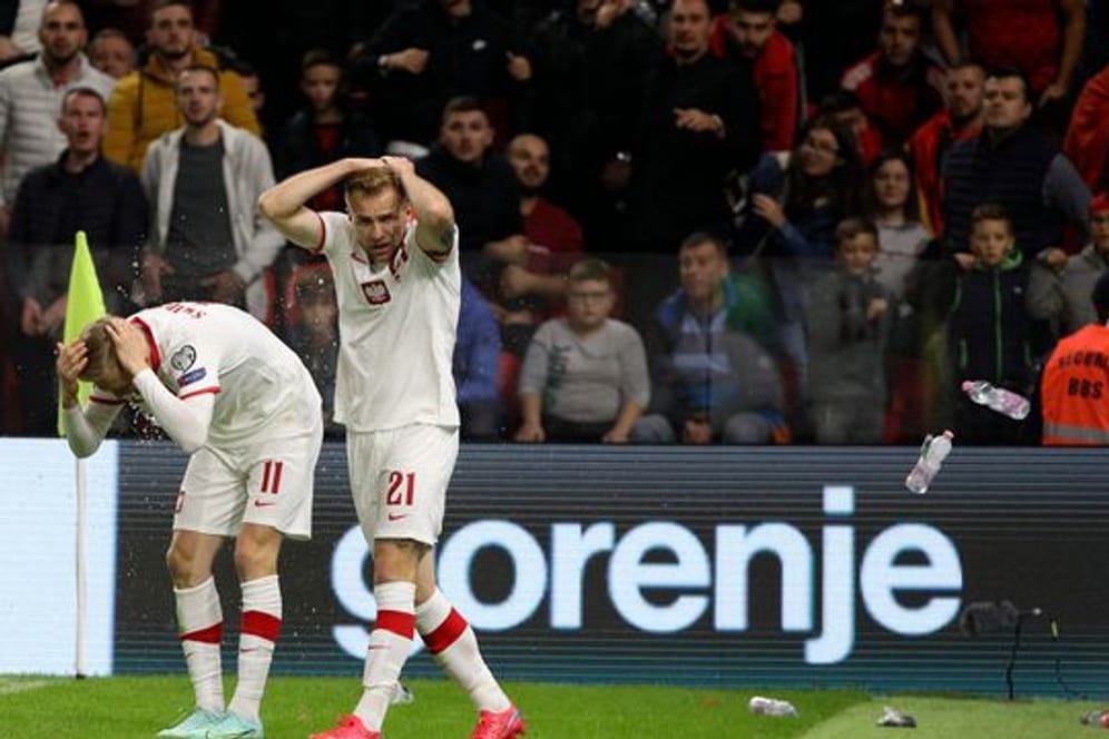 Polen Spieler schützen sich vor den Flaschenwürfen der albanischen Anhänger.