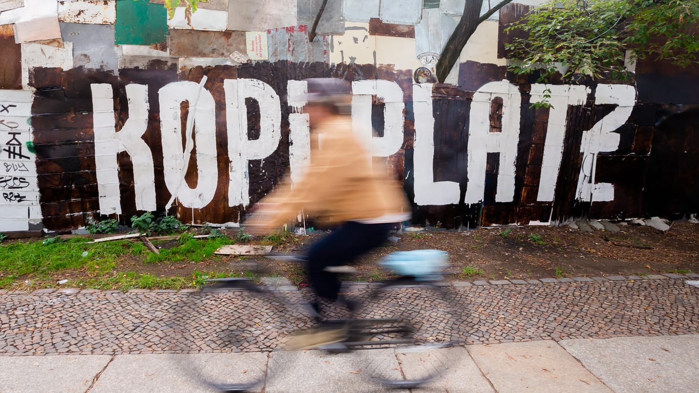 Ein Fahrradfahrer fährt am Zaun des links-autonomen Wohnprojekts und Kulturzentrums «Köpi» mit Wagenplatz in der Köpenicker Straße vorbei: Der "Köpi-Platz" soll am Freitag geräumt werden.