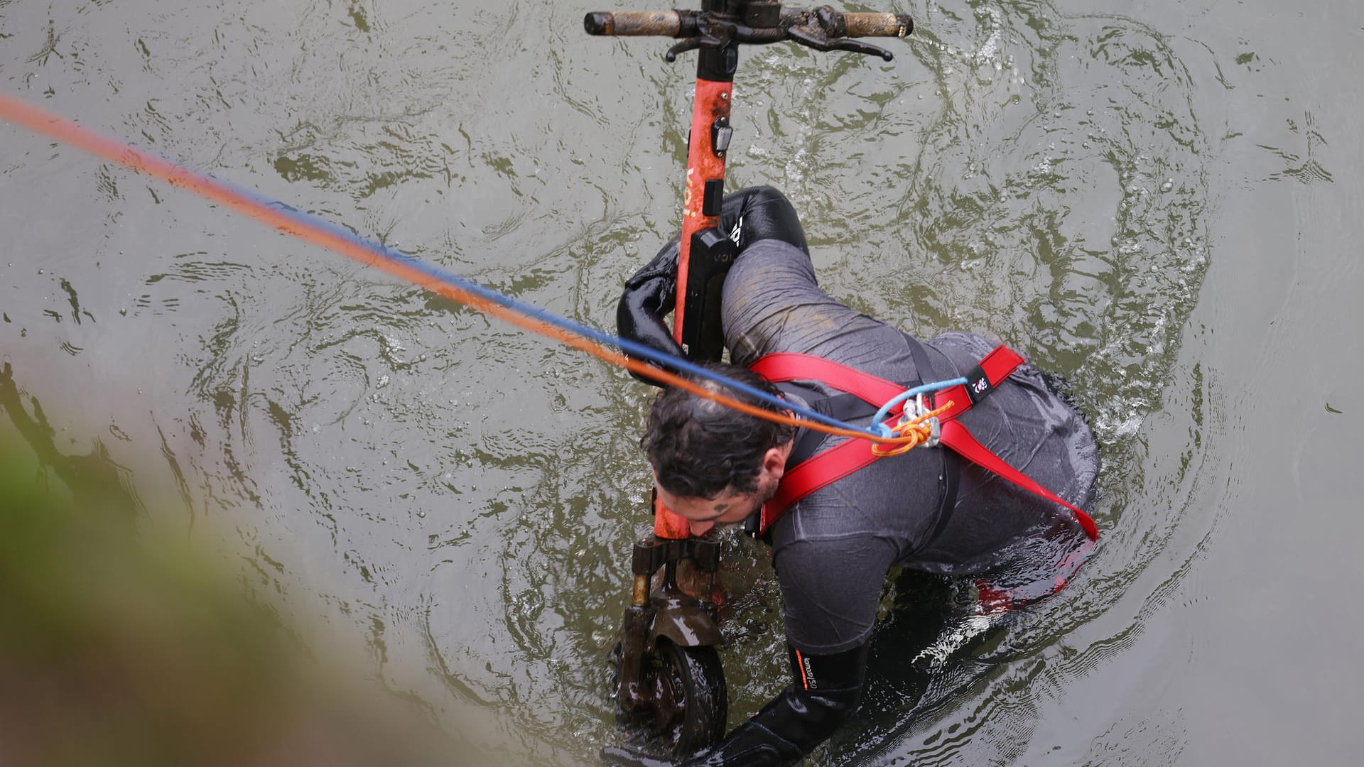 Im Neoprenanzug holte ein Mitglied der Bürgerinitiative Krake die E-Scooter aus dem Wasser.