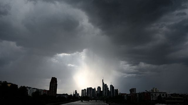 Dunkle Wolken ziehen über Hochhäuser hinweg