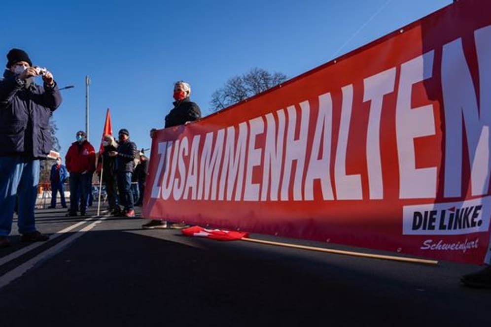 Banner der Linken mit der Aufschrift "Zusammenhalten"