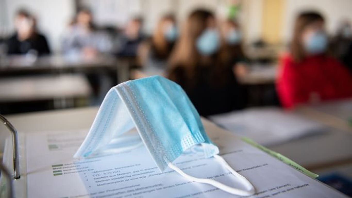 Ein Mund-Nasen-Schutz liegt im Unterricht auf Unterlagen