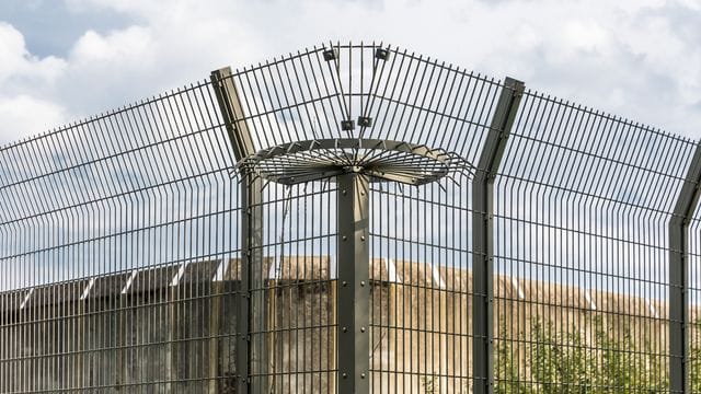 Eine Mauer und ein Drahtzaun eines Gefängnisses