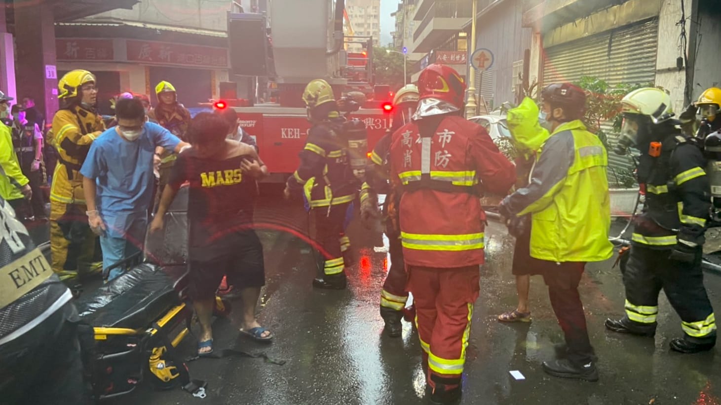 Feuerwehrleute und Rettungskräfte stehen während Löscharbeiten vor einem Hochhaus in der Innenstadt.