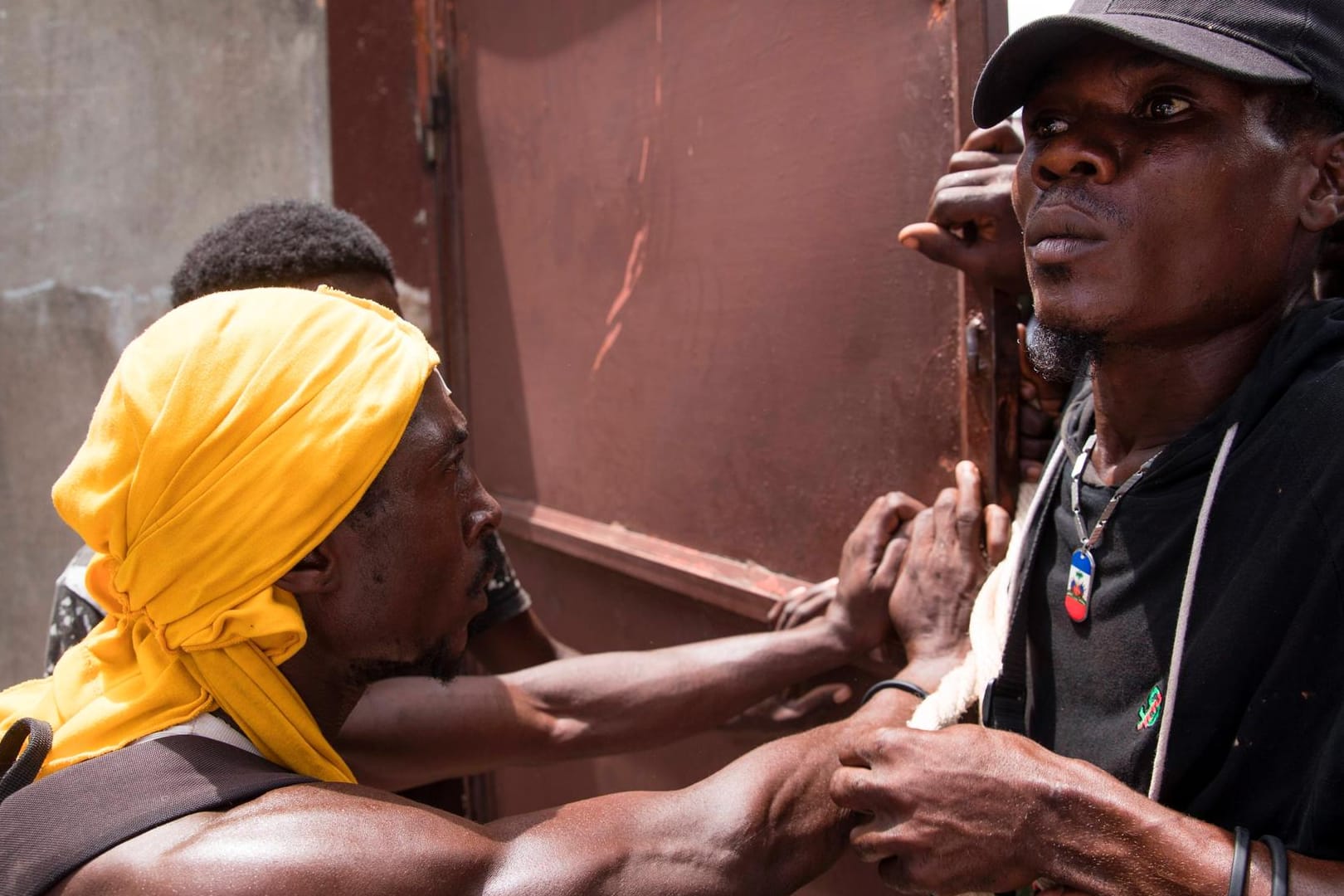 Hungersnot in Haiti: Ein Sicherheitsbeamter hält eine hungrige Menge in Schach.