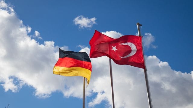 Deutsch und Türkische Flaggen wehen im Wind Deutsch und Türkische Flaggen wehen im Wind