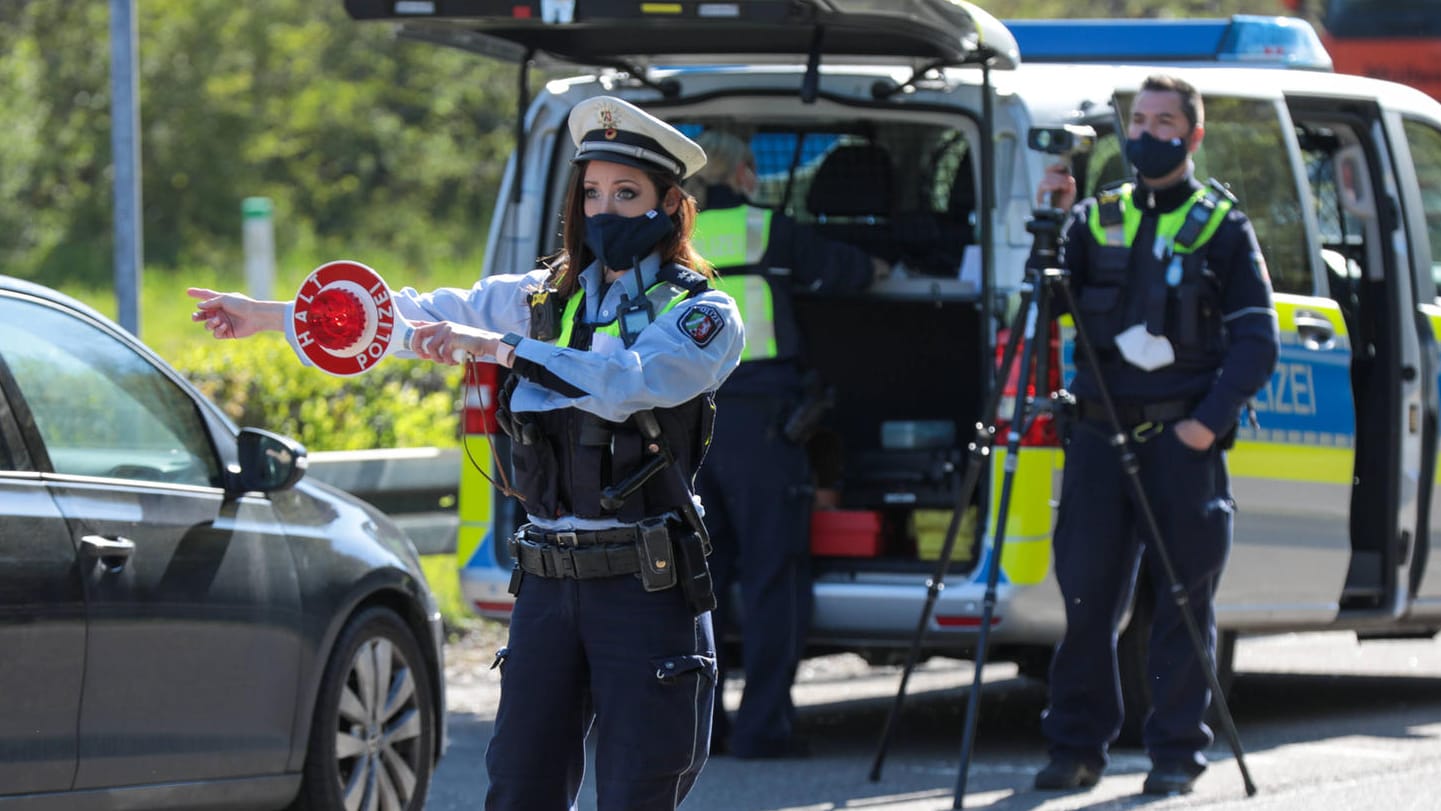 Polizeibeamter mit Polizeikelle: Bei einer Verkehrskontrolle ist es wichtig, sich korrekt zu verhalten.