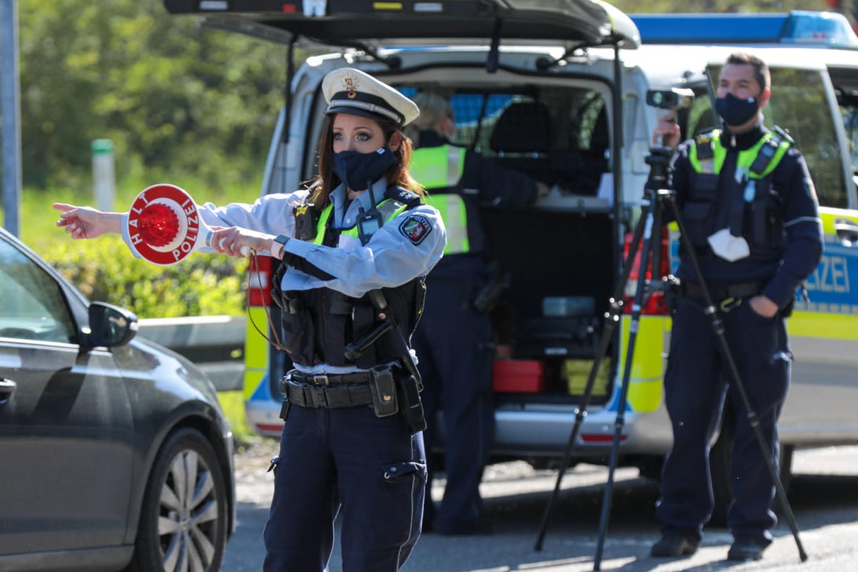 Polizeibeamter mit Polizeikelle: Bei einer Verkehrskontrolle ist es wichtig, sich korrekt zu verhalten.