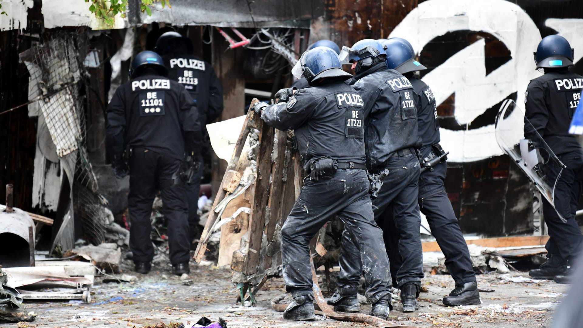 Polizisten räumen Barrikaden am Eingang der Bauwagensiedlung während der Räumung aus dem Weg: Mit schwerem Gerät hatten sich die Beamten den Weg frei gemacht.