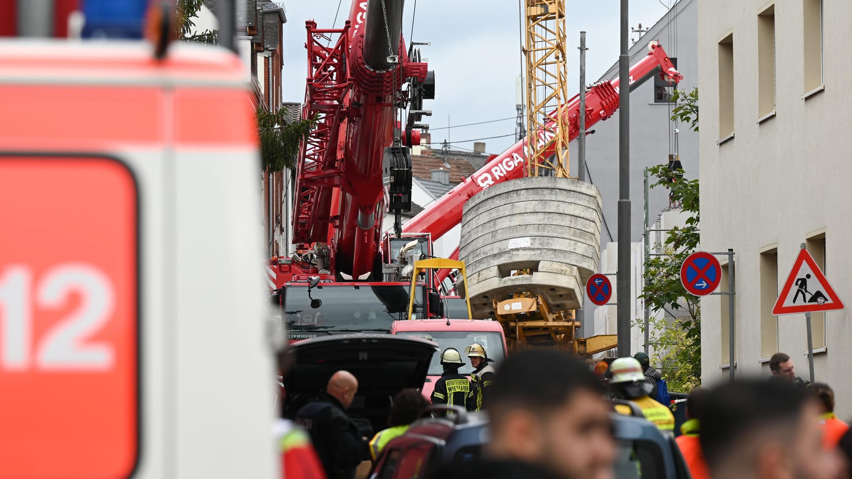 Einsatzkräfte bei der Unfallstelle: Mithilfe von Autokränen soll ein umgestürzter Baukran aufgerichtet werden.