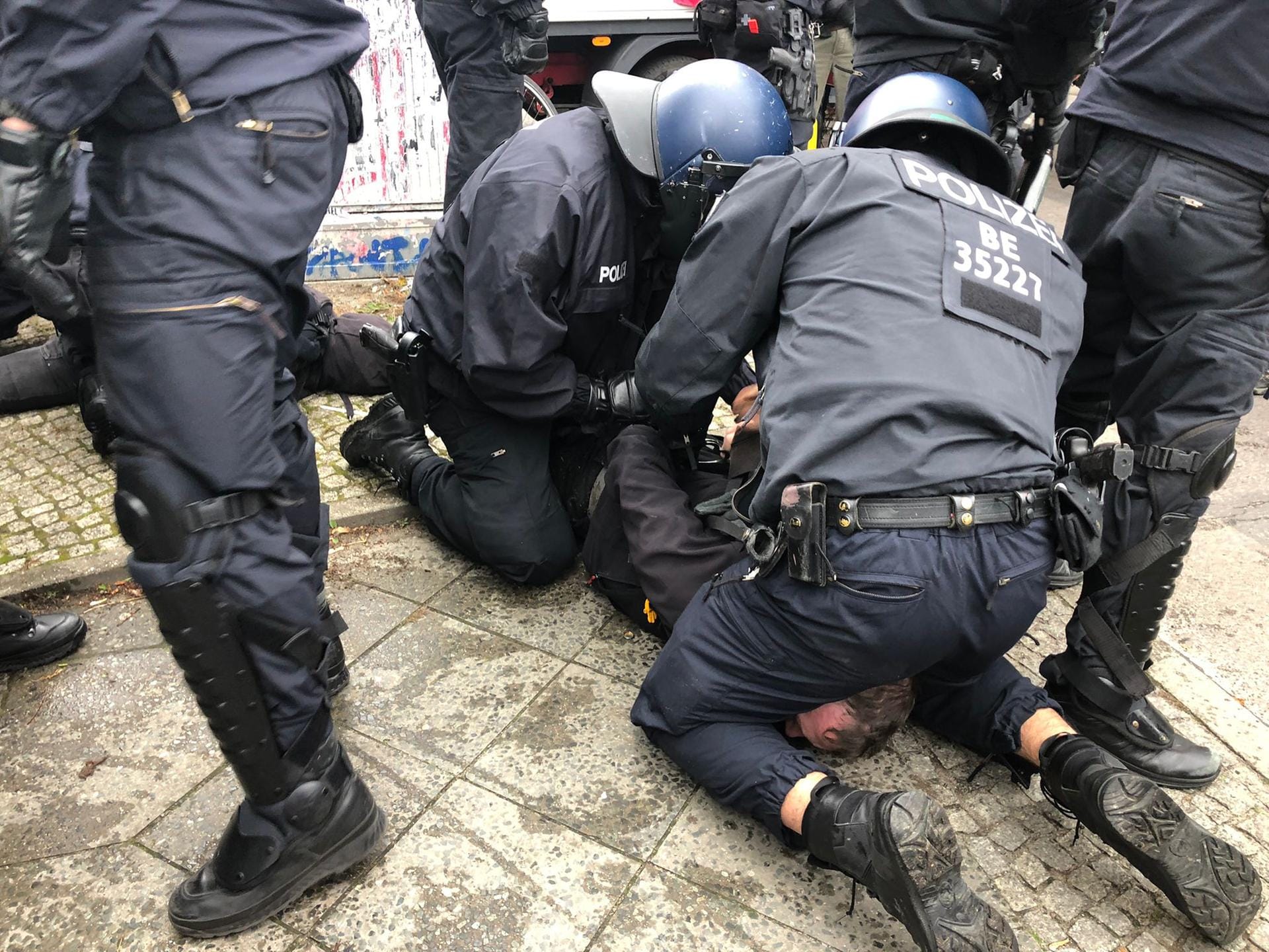 Zwei Polizisten halten eine Person fest: Die Demonstranten protestierten gegen die Räumung des "Köpi-Platzes".