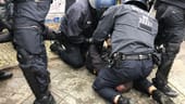 Zwei Polizisten halten eine Person fest: Die Demonstranten protestierten gegen die Räumung des "Köpi-Platzes".