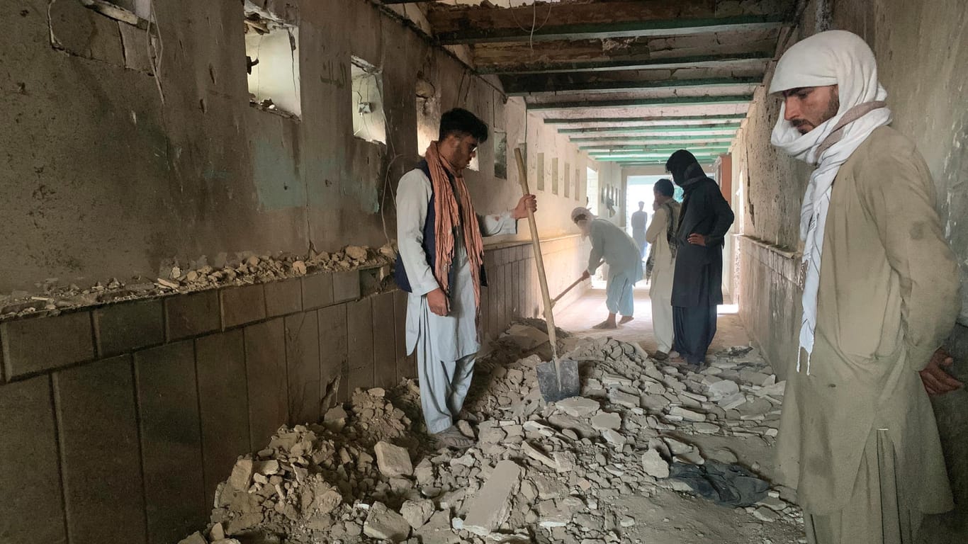 Menschen stehen in den Trümmern der Moschee: In Kandahar war es zu einer Explosion mit vielen Toten und Verletzten gekommen.