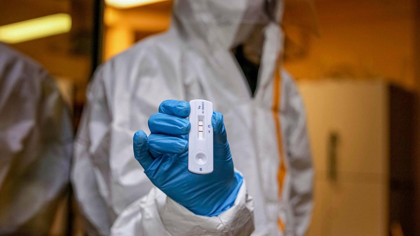 Ein Laborant hält in Hanau einen positiven Corona-Test hoch (Archivbild). In Deutschland sind bislang über 94.000 Menschen an dem Virus gestorben.