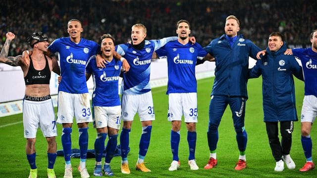Schalkes Spieler feiern den Last-Minute-Sieg in Hannover vor ihren mitgereisten Fans. Schalkes Spieler feiern den Last-Minute-Sieg in Hannover vor ihren mitgereisten Fans.