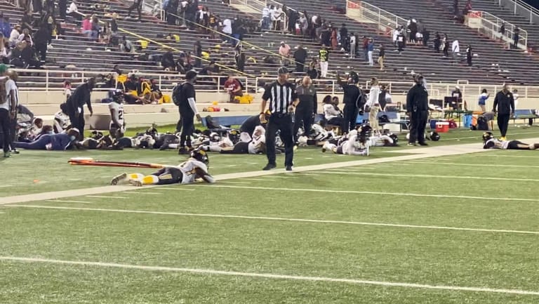 Das Ladd-Peebles-Stadion: Spieler liegen flach auf dem Boden während die Schüsse fallen.