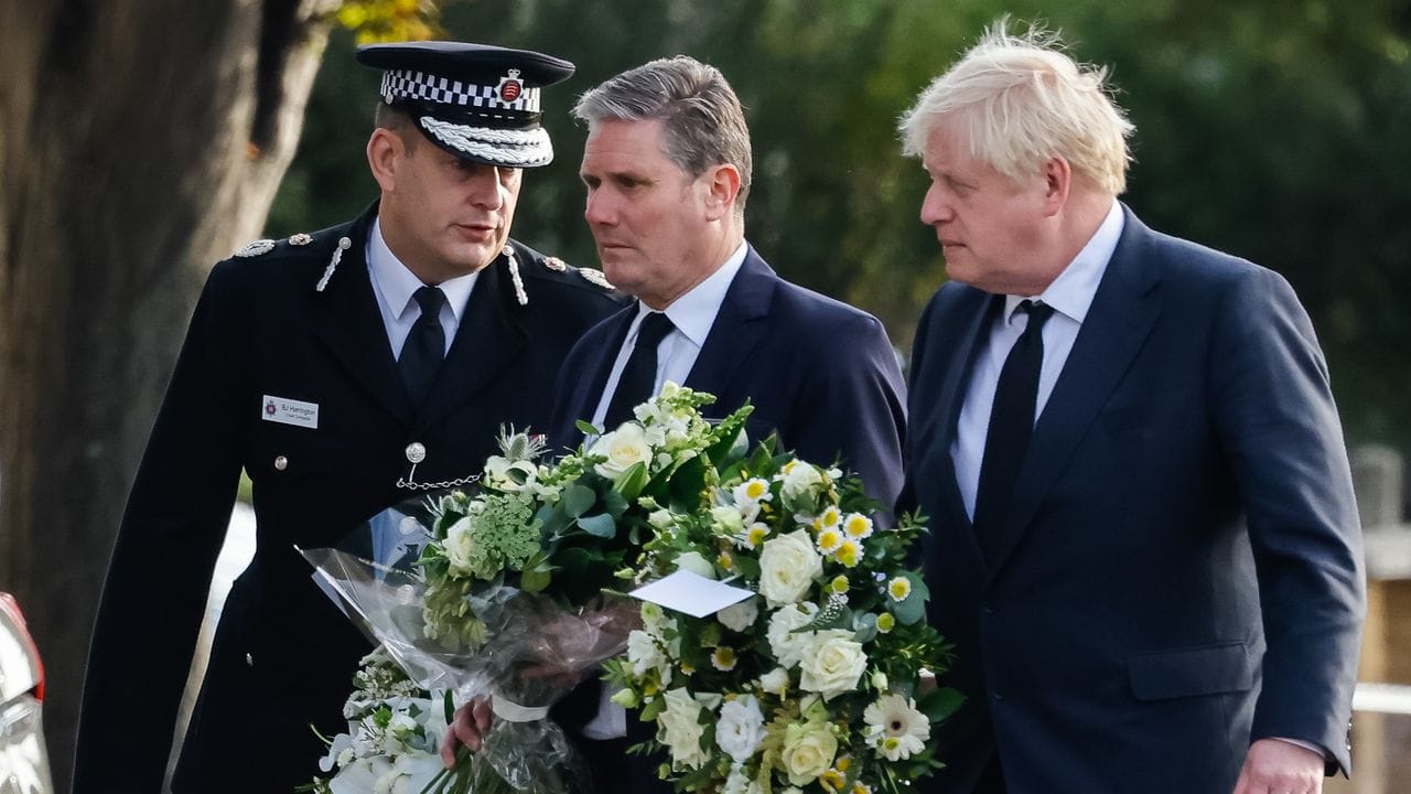 Premierminister Boris Johnson (r) zusammen mit Labour-Parteichef Keir Starmer (M) mit Blumen am Tatort.