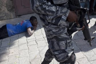 Ein Verdächtiger liegt auf dem Boden in Haiti, bewacht von einem Soldaten (Archivbild). Am Samstag sollen 17 amerikanische Missionare entführt worden sein.