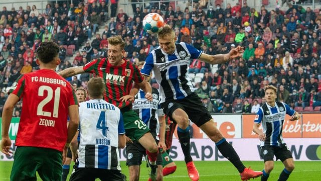 Augsburgs Andre Hahn (hinten, l) und Bielefelds Amos Pieper im Kopfballduell. Augsburgs Andre Hahn (hinten, l) und Bielefelds Amos Pieper im Kopfballduell.