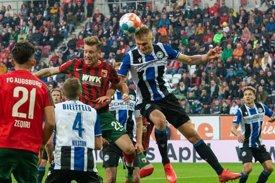 Augsburgs Andre Hahn (hinten, l) und Bielefelds Amos Pieper im Kopfballduell.