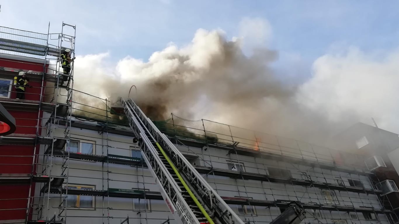Flammen und Rauch sind am Dach des Gebäudes zu sehen: Anwohner sind aufgerufen, Türen und Fenster geschlossen zu halten.