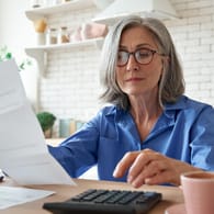 Ältere Frau mit einem Taschenrechner (Symbolbild): Wie viel Rente Sie bekommen, hängt maßgeblich vom Bruttolohn ab.