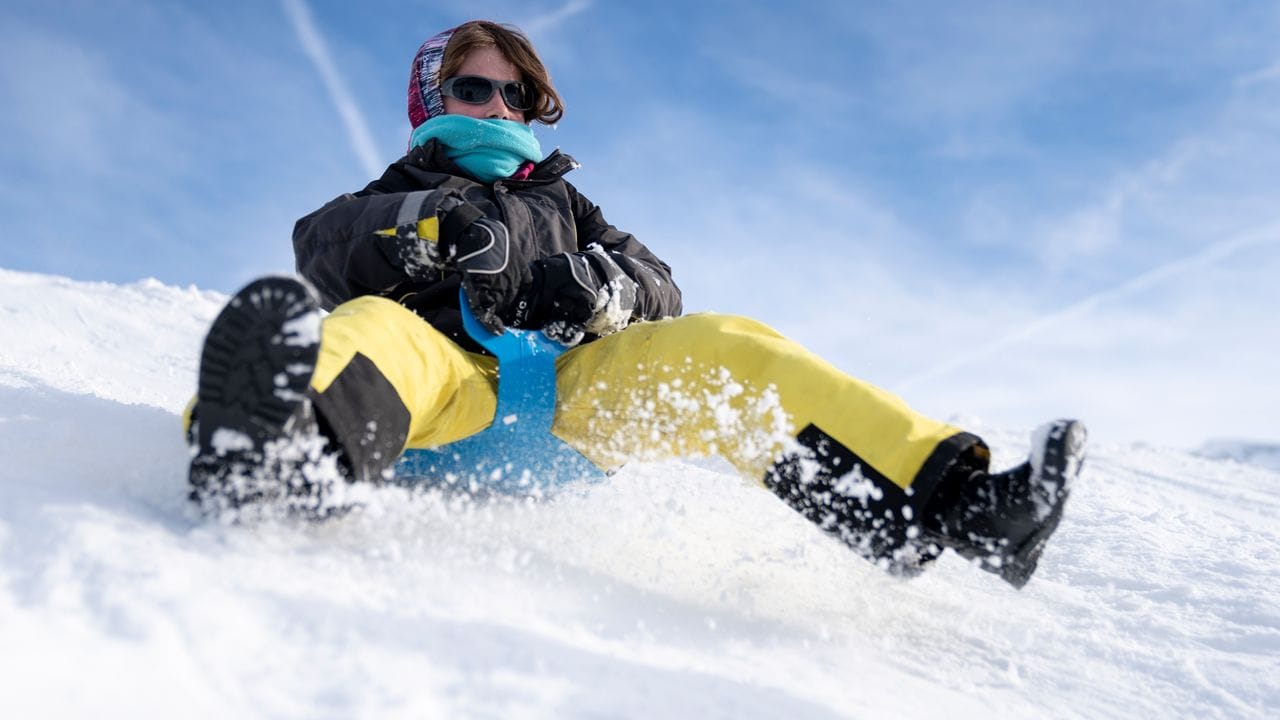 Auf einem Schlitten oder Schneerutscher können die Beine schnell mal irgendwo hängen bleiben - zu Leiden von Sprunggelenk oder Knie.