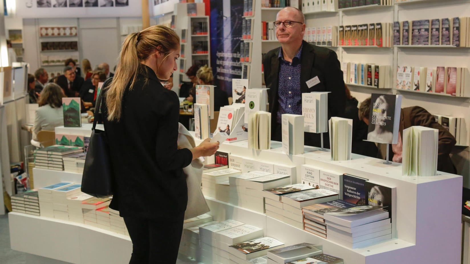 Eine Frau vor einem Stand mit Büchern: Due Verlage stehen wegen hoher Papierpreise unter Druck.