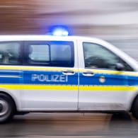 Ein Streifenwagen der Polizei ist mit Blaulicht unterwegs (Symbolbild): In Stuttgart sucht die Polizei weiter nach einem mutmaßlichen Vergewaltiger.