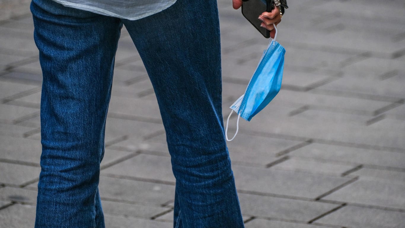 Ein Mann mit Maske an der Hand (Symbolbild): Hamburg weitet die 2G-Regeln auf auf das Einkaufen im Einzelhandel aus.