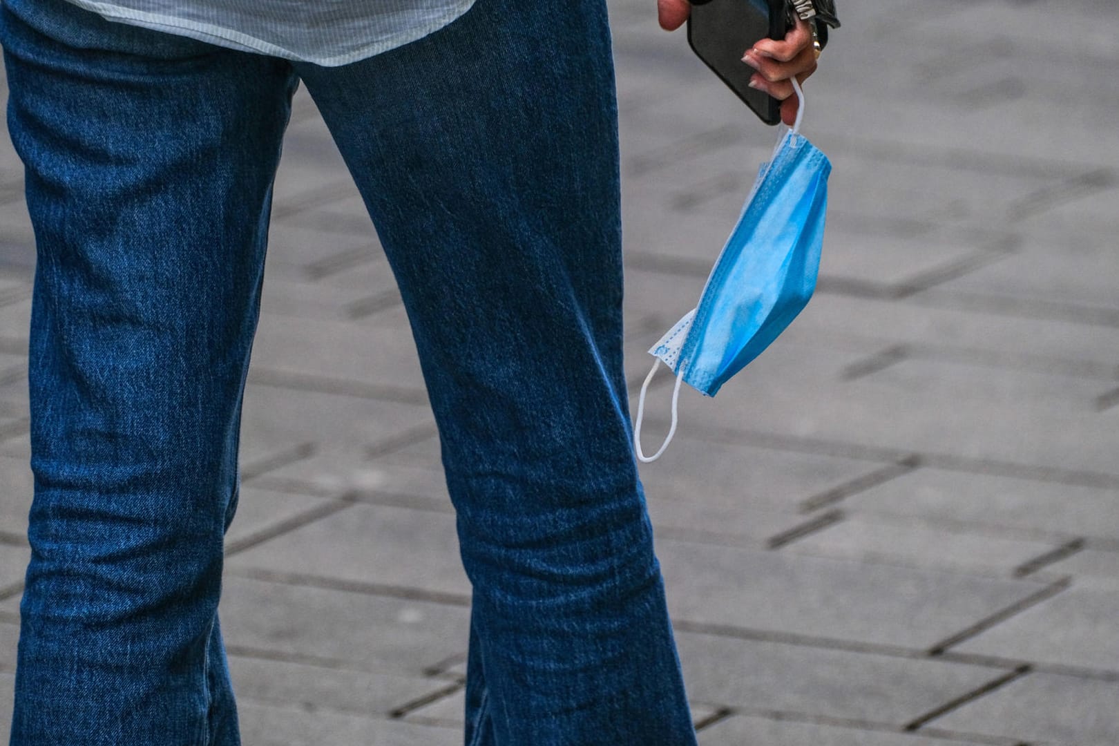 Ein Mann mit Maske an der Hand (Symbolbild): Hamburg weitet die 2G-Regeln auf auf das Einkaufen im Einzelhandel aus.