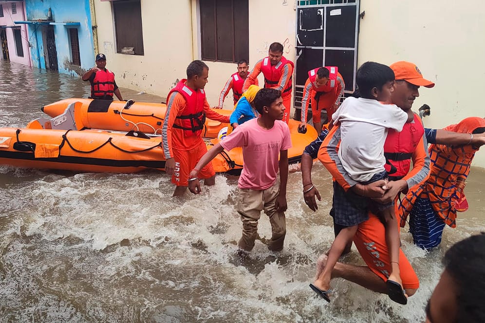 Rettungskräfte helfen Menschen: Eine Flut nach starken Regenfällen hat in Indien mindestens 32 Opfer gefordert.