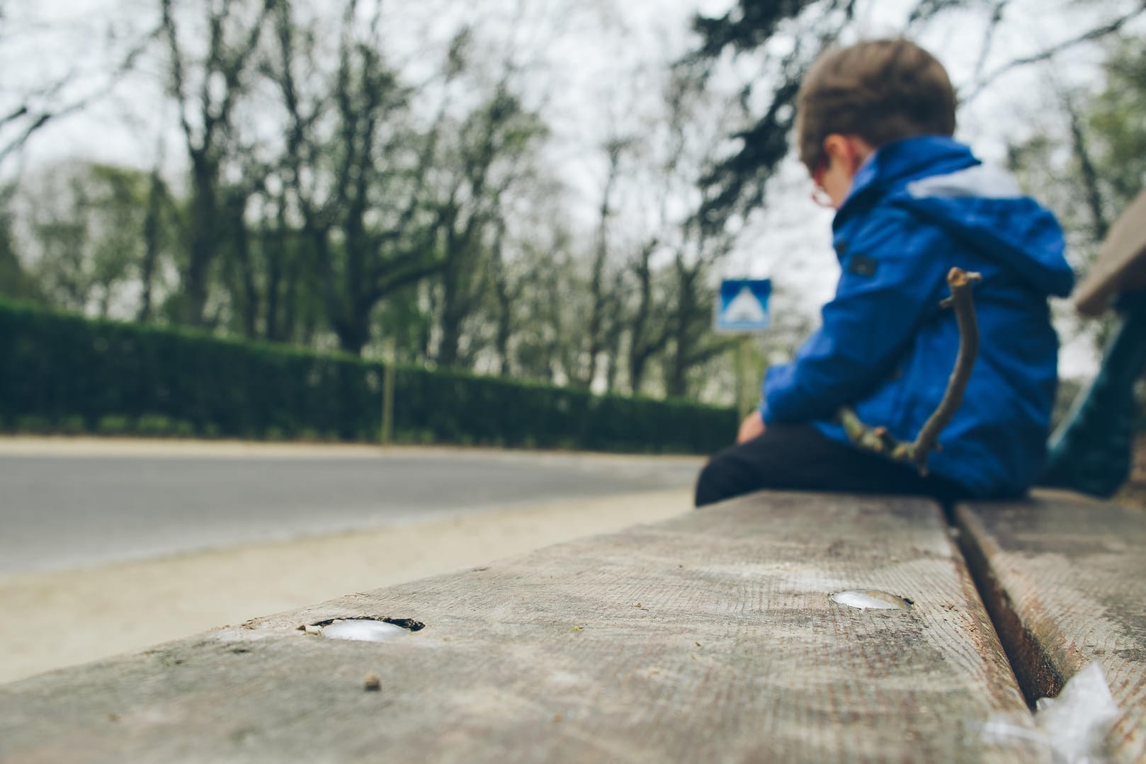 Einsam wirkender Junge auf einer Bank: Kinder mit frühkindlichem Autismus schotten sich von anderen Menschen ab.