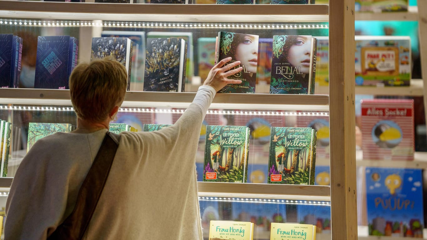 Frau in einem Buchladen: Die Buchbranche kämpft mit hohen Papierpreisen.