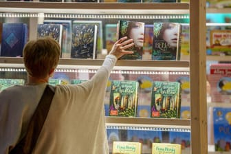 Frau in einem Buchladen: Die Buchbranche kämpft mit hohen Papierpreisen.