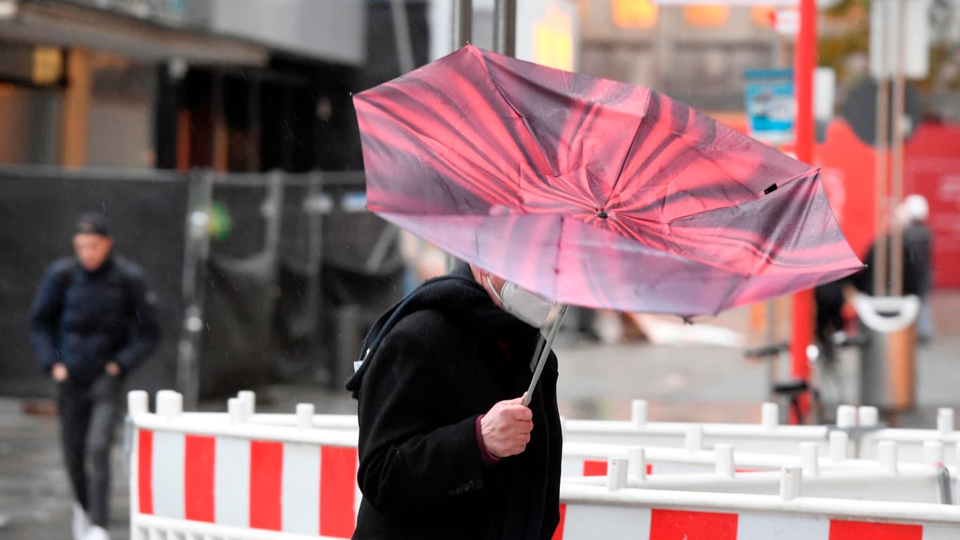 Der Regenschirm eines Passanten in Köln wird vom Sturm erfasst: Der Wetterdienst hat für heute im südlichen Nordrhein-Westfalen eine Unwetterwarnung mit orkanähnlichen Böen und Starkregen vorhergesagt.