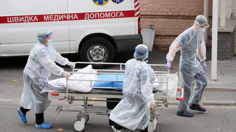 Medizinisches Personal schiebt einen Wagen aus einer Corona-Abteilung in Kiew: Die Ukraine kämpft mit einem Allzeithoch an Infektionen und Todesfällen.
