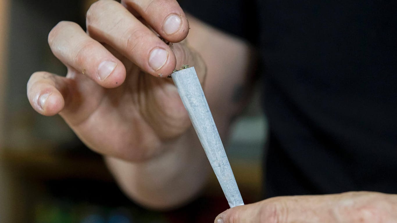 Ein Mann rollt einen Joint zusammen (Symbolbild). Deutsche Kriminalbeamte wollen Cannabis-Konsum zur Ordnungswidrigkeit herunterstufen.