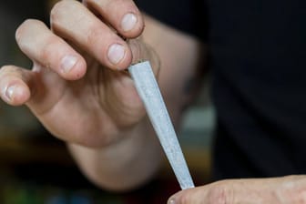 Ein Mann rollt einen Joint zusammen (Symbolbild). Deutsche Kriminalbeamte wollen Cannabis-Konsum zur Ordnungswidrigkeit herunterstufen.