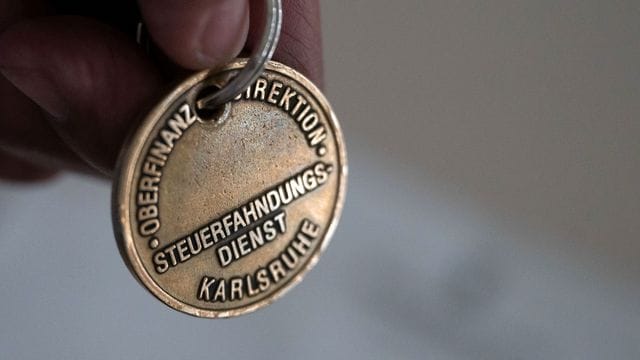 Ein Steuerfahnder zeigt seine Dienstmarke