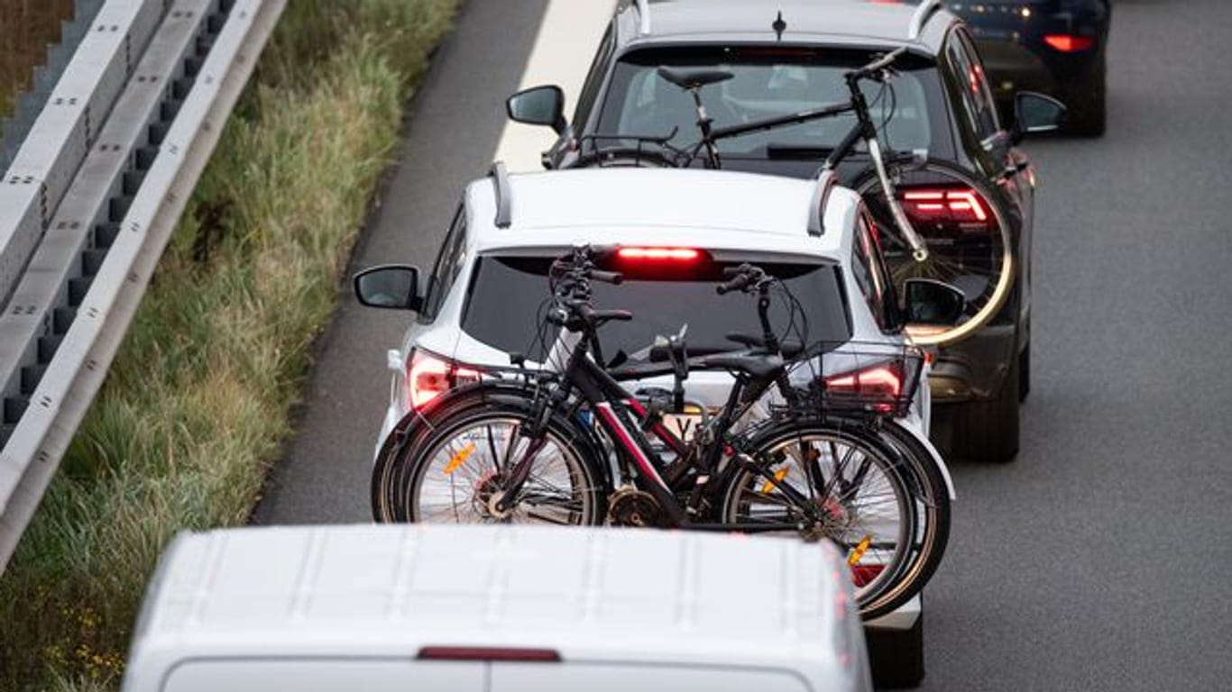 Zwei Fahrzeuge mit Fahrrädern im Gepäck stehen auf einer Autobahn