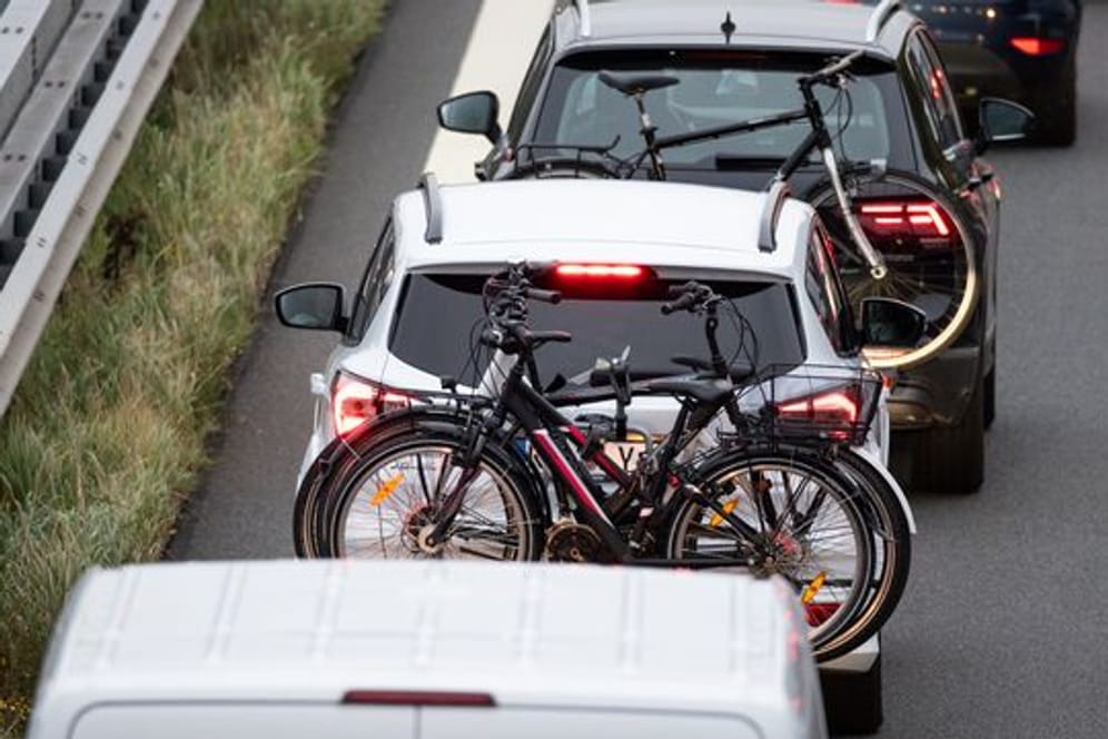 Zwei Fahrzeuge mit Fahrrädern im Gepäck stehen auf einer Autobahn