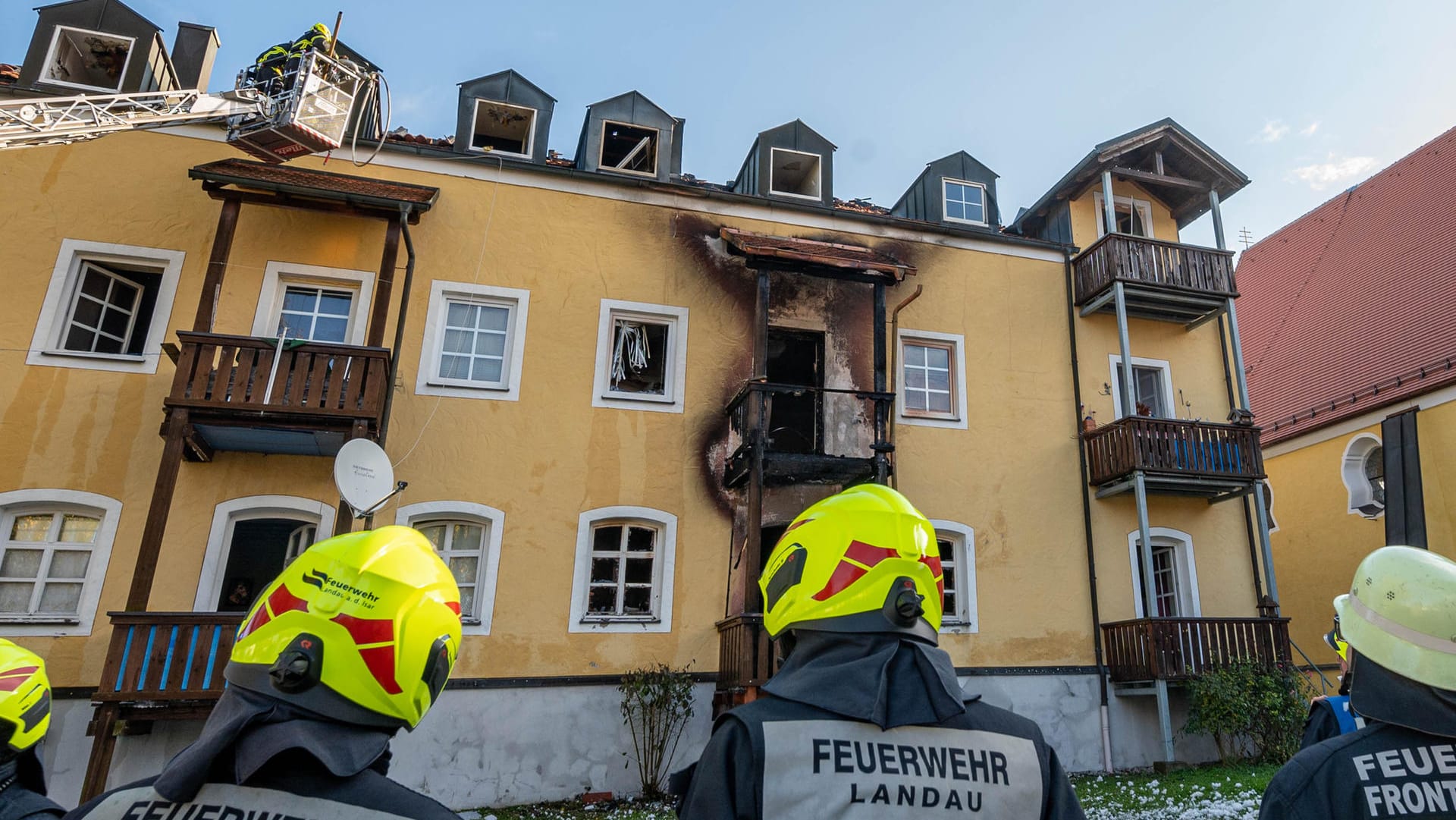 Feuerwehrmänner stehen vor dem ausgebrannten aus: Drei Frauen und ein Baby kamen bei dem Brand ums Leben. Feuerwehrmänner stehen vor dem ausgebrannten aus: Drei Frauen und ein Baby kamen bei dem Brand ums Leben.